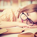 tired student girl with glasses sleeping on the books in the library
** Note: Shallow depth of field